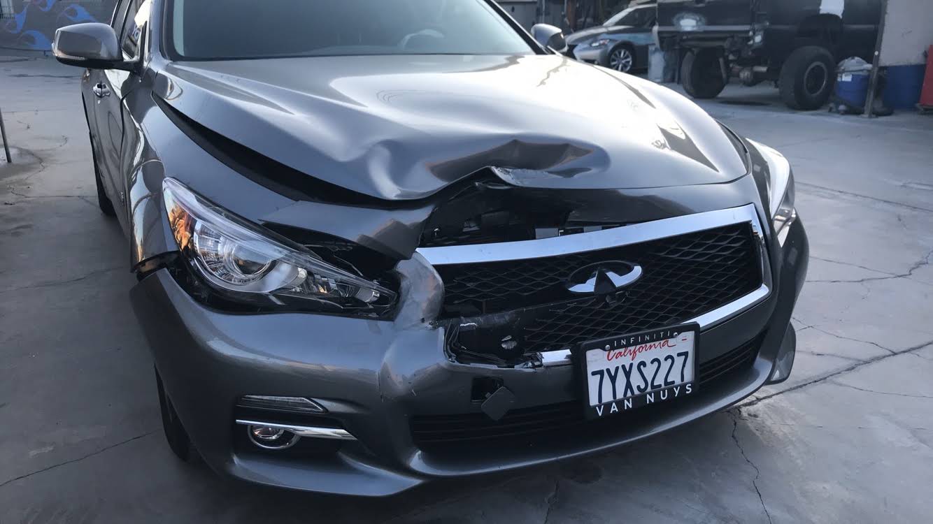 Gray Infiniti with hood, grille, and front bumper collision damage before repair